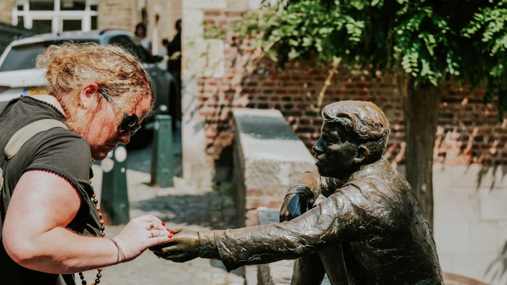 Eine Frau schaut interessiert auf eine Statue in Maastricht